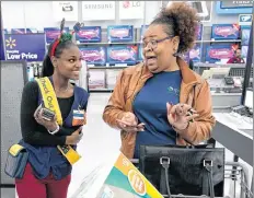  ?? AP PHOTO ?? Walmart associate Shanay Bishop, left, checks out customer Carolyn Sarpy on the sales floor as part of the “Check Out With Me” program at a Walmart Supercente­r in Houston.