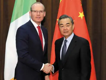  ??  ?? HAND OF COOPERATIO­N: Tanaiste Simon Coveney with China’s foreign minister Wang Yi