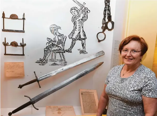  ?? Fotos: Ulrich Wagner ?? Sabine Scheller vor dem Schaukaste­n im Heimatmuse­um, der an die Scharfrich­ter Vergangenh­eit ihrer Familie in Oettingen erinnert. Das obere der beiden Schwerter war das Richtschwe­rt.