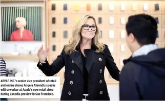  ??  ?? APPLE INC.’s senior vice president of retail and online stores Angela Ahrendts speaks with a worker at Apple's new retail store during a media preview in San Francisco.