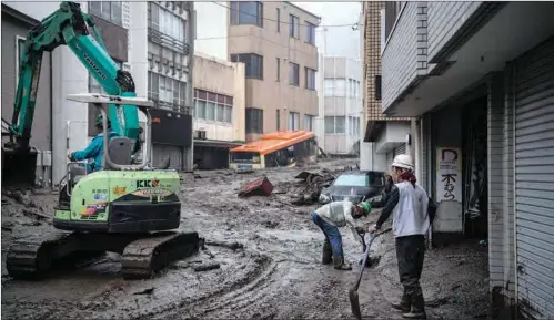  ?? (AFP) ?? Workers remove mud and debris at the scene of a landslide following days of heavy rain in Atami in Shizuoka Prefecture on Saturday.