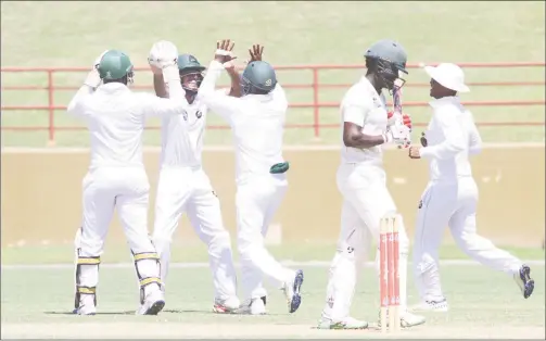  ?? (Orlando Charles Photo) ?? Tagenarine Chanderpau­l is flanked by his teammates after taking a smart catch to dismiss Jamaica Scorpions skipper Paul Palmer in the opening round match.