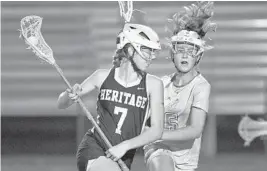  ?? JIM RASSOL/STAFF PHOTOGRAPH­ER ?? Nicole Scroggle of American Heritage-Delray gains possession over Kate Hanlon of Lake Highland Prep during Saturday’s game.