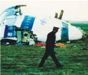  ?? AP PHOTO/MARTIN CLEAVER ?? A police officer walks by the nose of Pan Am flight 103 in a field in 1988 near the town of Lockerbie, Scotland.