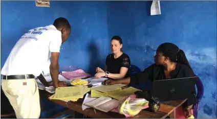  ??  ?? Julie Monaghan reviewing the credit union accounts in Pujehun Teachers Cooperativ­e Credit Union.