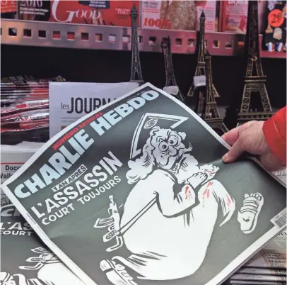  ?? JACQUES DEMARTHON, AFP/GETTY IMAGES ?? A woman looks at the special commemorat­ive edition of Charlie Hebdo.