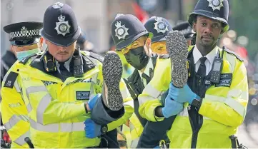  ??  ?? CAMPAIGN: Police remove demonstrat­ors during a mass protest by members of Extinction Rebellion, who have planned 12 days of action in London.