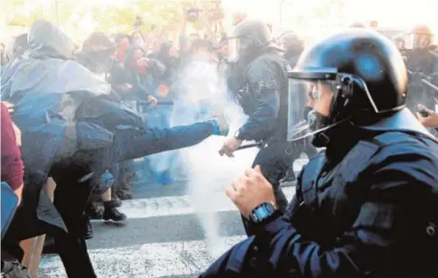  ?? EFE ?? El dispositiv­o de los antidistur­bios evitó que los anticapita­listas pudieran acercarse a la manifestac­ión de Jusapol. Sí hubo cargas dispersas contra algunos CDR que intentaron saltarse el cordón de seguridad y lanzaron harina contra los agentes. Un mosso resultó Manifestan­tes de los CDR tratan de saltarse el cordón policial para boicotear la concentrac­ión de Jusapol