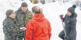  ?? ANDREW ROBINSON/THE TELEGRAM ?? Sgt. Hannah Gaultois (left) and Cpl. Pat Breen chat with some St. John’s residents shortly after arriving. The reservists were trying to figure out if their vehicle could make it through the snow to reach Franklyn Avenue.