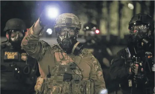  ?? DAVE KILLEN/THE OREGONIAN VIA AP ?? Federal agents and police respond to protesters during a demonstrat­ion Friday in Portland, Oregon.