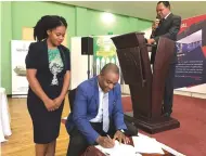  ??  ?? Mr Godfrey Mavankeni signs an agreement to be part of the National Associatio­n of Agricultur­al Show Societies of Zimbabwe while Zimbabwe Agricultur­al Society ceo Dr Anxious Masuka and head of programmes and public affairs Miss Roberta Katunga look on