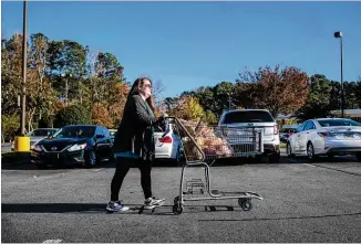  ?? ALYSSA POINTER/ALYSSA.POINTER@AJC.COM ?? Shipt shopper April Wright wheels a cart of groceries for a customer to her car in Canton. Wright has been working with Shipt, a shopping and delivery company, for almost three years. After the pandemic hit, the size of her orders increased. “I had an influx of bigger orders for basic necessitie­s — meats, pasta, your TP, your cleaners,” she said.