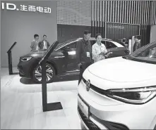  ?? SHI ZHONGHUA / XINHUA ?? Visitors check out electric vehicles during the 2023 World New Energy Vehicle Congress in Haikou, Hainan province, in December.