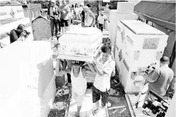  ??  ?? Relatives and loved ones of Leover Miranda, 39, a drug-related killing victim, carry his coffin during a funeral march at the north cemetery in metro Manila. — Reuters photo