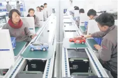  ??  ?? Students work on an improvised car assembly line as a group of foreign reporters visits a vocational school on a government organised tour in Lhasa, Tibet Autonomous Region, China. — Reuters photo