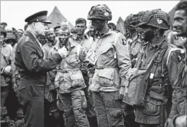  ?? ASSOCIATED PRESS FILE ?? Gen. Dwight D. Eisenhower, Allied Commander in Chief, gives the order of the day “Full Victory, nothing Else” to paratroope­rs somewhere in England June 6, 1944, just before they board their plans to participat­e in the first assault on the Coast of...