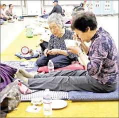  ??  ?? Residents from a quake-hit area eat their dinner at a shelter.