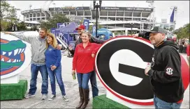  ?? PHOTOS BY BOB ANDRES / ROBERT.ANDRES@AJC.COM ?? Georgia and Florida fans gather outside the stadium Friday. Activities included tailgating, Fan Fare and a UGA-Florida exhibition baseball game.