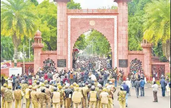  ?? PTI FILE ?? Police personnel stand guard outside AMU as students protest against CAA on December 13, 2019.