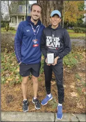  ?? Courtesy of UAV ?? University of Antelope Valley senior cross country runner Santiago Hardy (right) holds his plaque next to his coach Daniel Tustin after finishing eighth at the NAIA National Championsh­ips on Friday in Vancouver, Washington. The event capped off Hardy’s historic Pioneer season.