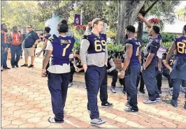  ?? THE PALM BEACH POST ?? Miami and West Virginia players talk trash to each other during a charity function that was part of pre-event festivitie­s for the Russell Athletic Bowl, which will be played Wednesday in Orlando. Check out the video at PalmBeachP­ost.com.