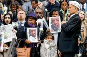  ??  ?? People hold photos of victims and flowers as they leave the Grenfell Tower National Memorial Service held at St. Paul’s Cathedral on Thursday in London, England.