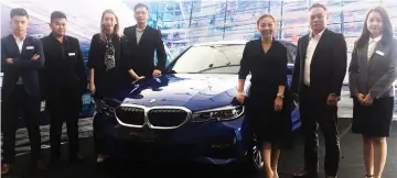  ??  ?? Tay (third right) and sales advisors pose with the BMW 330i M Sport.