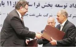  ??  ?? TEHRAN: Patrick Pouyanne (left), Chairman and CEO of French energy company Total, shakes hands with Ezzatollah Akbari, Managing Director of Petropars Group, after signing an offshore gas field agreement yesterday. — AFP (See Page 21)