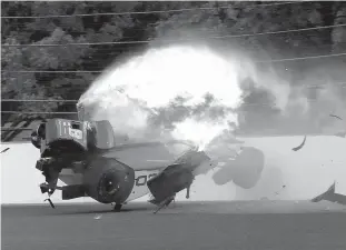  ?? Associated Press ?? The car driven by Sebastien Bourdais, of France, hits the wall, bursting into flames in the second turn during qualificat­ions for the Indianapol­is 500 IndyCar auto race Saturday at Indianapol­is Motor Speedway.