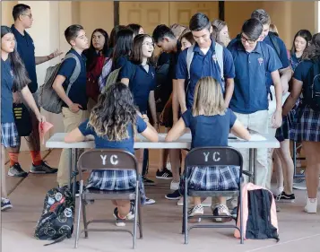  ??  ?? YUMA CATHOLIC HIGH SCHOOL STUDENTS PICK UP THEIR CLASS SCHEDULES Thursday morning before the first class of the 2017-18 school year.