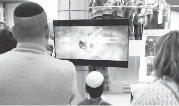  ?? — AFP photo ?? People watch a screen showing explanatio­ns of the landing of Israeli spacecraft, Beresheet’s, at the Planetaya Planetariu­m in the Israeli city of Netanya before it crashed during the landing.