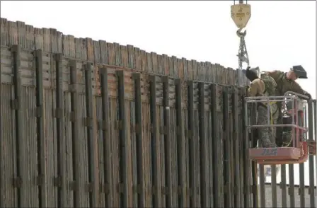  ?? KHAMPHA BOUAPHANH — THE ASSOCIATED PRESS ?? Utah National Guard soldiers work on extending a border fence in San Luis, Ariz., President Donald Trump said he wants to use the military to secure the U.S.-Mexico border until his promised border wall is built. The Department of Homeland Security and...