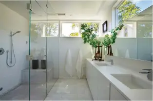  ??  ?? The master bathroom is flooded with natural light. The busts are from Darryl Carter Design and Home Boutique.