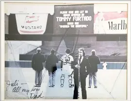  ??  ?? A photo shows Juliana Furtado’s father, Tommy Furtado, singing “America the Beautiful” at Yankee Stadium. He signed it, “Juli, All my love - Dad.”