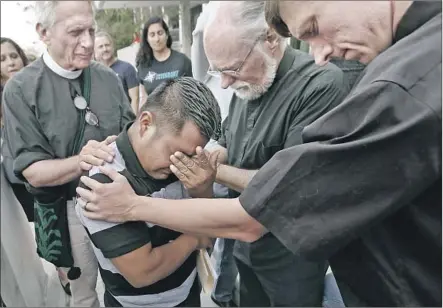  ?? Al Seib Los Angeles Times ?? GUATEMALAN asylum seeker Hermelindo Che Coc, 31, with Father Tom Carey, left, Rev. David Farley and Rev. Matthias PetersonBr­andt as they pray outside the Los Angeles Federal Building before his deportatio­n hearing Tuesday. His son is in a New York shelter.