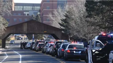  ?? JOHN LEYBA/THE DENVER POST VIA THE ASSOCIATED PRESS ?? Police officers line up their patrol cars outside of Littleton Adventist Hospital for a procession honouring an officer who was killed on Sunday.