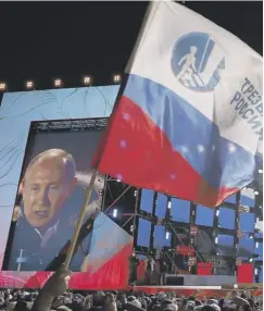  ??  ?? 0 Putin supporters flying the flag at a rally in Moscow