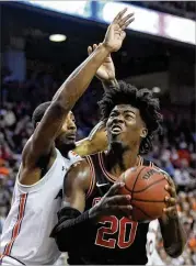  ?? JULIE BENNETT / AP ?? UGA forward Rayshaun Hammonds is defended by Anfernee McLemore, a senior from Worth County, in the Tigers’ 82-60 blowout of the Bulldogs.