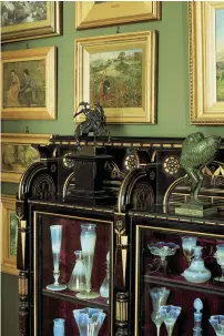  ??  ?? ABOVE Nineteenth-century oil paintings on a brilliant green wall and a favorite collection on display: very English. The ebonized Aesthetic cabinet is by Cottier.