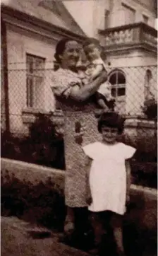  ?? (Courtesy) ?? THE WRITER’S great aunt Rachel Birnbach holds her son Natan and stands with daughter Chajcia in front of their house, which still exists.