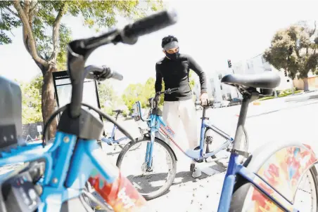  ?? Scott Strazzante / The Chronicle ?? Jalinn Ahmad prepares to bike to his sister’s San Francisco apartment. He was laid off from one tech job but found another.