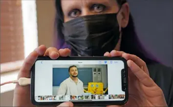 ?? LM Otero/Associated Press ?? Carrie Shipp shows a photo of her incarcerat­ed 21-year-old son Matthew Shipp that she keeps on her cellphone on April 2 in Irving, Texas. Ms. Shipp said her son decided not to get vaccinated out of fear and distrust of prison medical staff.