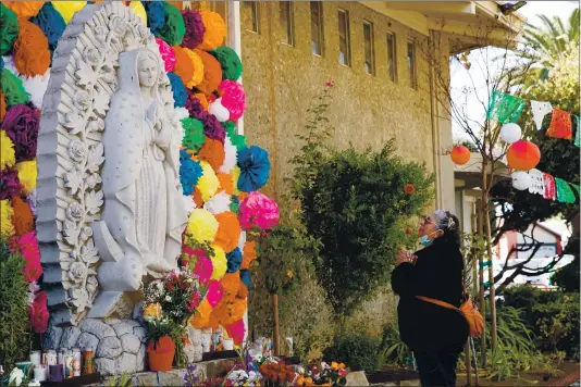  ?? RANDY VAZQUEZ — STAFF PHOTOGRAPH­ER ?? Lourdes Montiel prays at a statue of La Virgen de Guadalupe at Our Lady of Guadalupe Church in San Jose. Montiel’s husband was hospitaliz­ed with COVID-19. She and her family left roses for La Virgen’s response to their prayers. Testing in the 95127 ZIP code in East San Jose lagged far behind more affluent communitie­s such as Cupertino.
