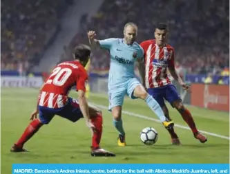  ??  ?? MADRID: Barcelona’s Andres Iniesta, centre, battles for the ball with Atletico Madrid’s Juanfran, left, and Angel Correa during a Spanish La Liga soccer match between Atletico Madrid and Barcelona. —AP