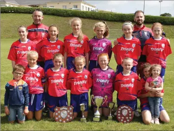  ??  ?? The Curracloe United Under-12 girls’ soccer team, winners of the Under-12 League, Under-12 Cup, Under-11 League, Under-11 Cup, and the 20/20 Cup competitio­n held in Home Farm, Dublin. They are pictured with coaches Mick Redmond and Peadar Carley wearing their new jerseys sponsored by Trinity Peugeot.