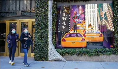  ?? AP PHOTO BY MARY ALTAFFER ?? Black Friday shoppers wear face masks as they leave Saks Fifth Avenue flagship’s store empty handed, Friday, Nov. 27, in New York.