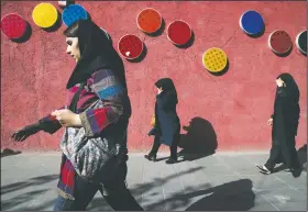  ?? AP/VAHID SALEMI ?? Pedestrian­s make their way along a sidewalk Saturday in downtown Tehran, Iran.