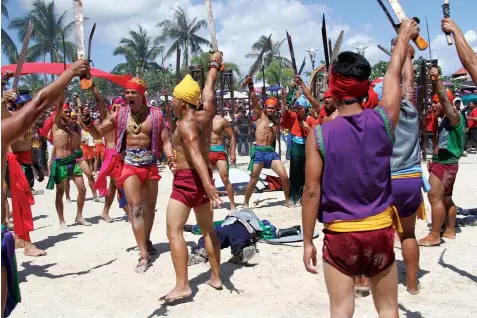  ?? JOY TORREJOS ?? Local warriors headed by Lapu-Lapu, played yesterday by television personalit­y Daniel Matsunaga, raise their swords in victory after defeating the Spaniards in the shores of Mactan during yesterday's reenactmen­t of the historic battle in the island.