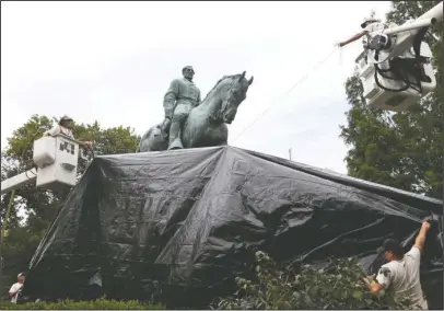  ?? The Associated Press ?? MONUMENT: City workers drape a tarp over the statue of Confederat­e General Robert E. Lee in Emancipati­on park Wednesday in Charlottes­ville, Va. The move to cover the statues is intended to symbolize the city's mourning for Heather Heyer, killed while...