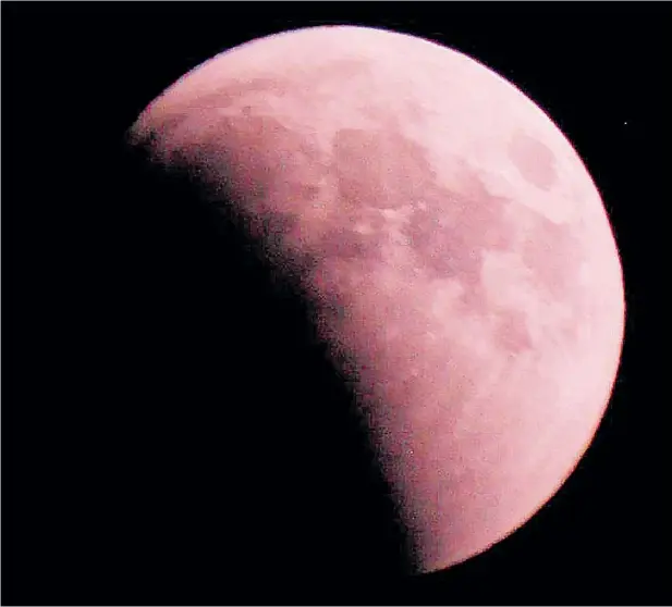  ??  ?? The blood moon pictured in Najaf, Iraq, last night. Sky-gazers in Oxfordshir­e and Scotland also had a good view of the rising full moon changing colour to red